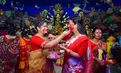 Women apply sindur (vermilion) on each other during the Sindoor Khela,
