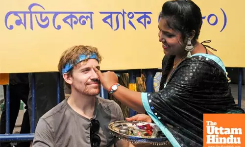 A woman applies a traditional tilak to a tourist on the occasion of the Bhai Dooj festival