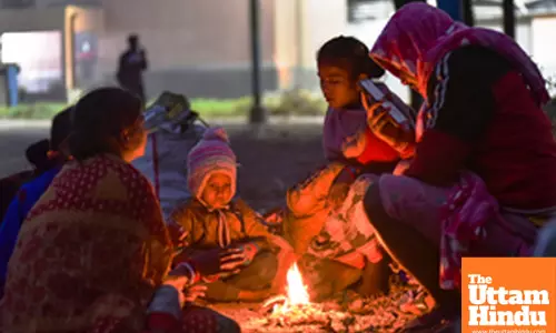 Kolkata: People sit around a bonfire to keep themselves warm on a cold winter evening