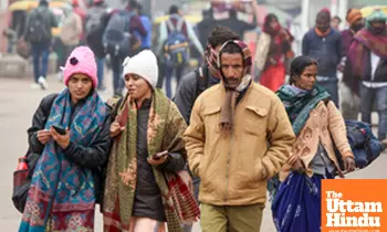 Lucknow: Commuters wearing warm clothes walk past Charbagh railway station on a cold winter day