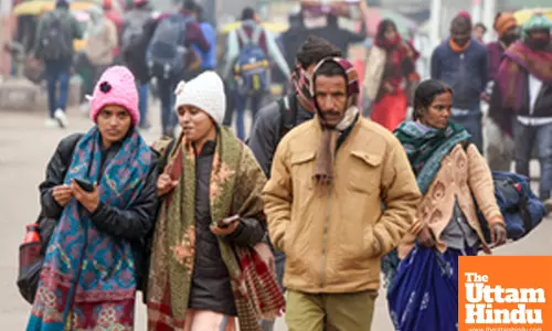 Lucknow: Commuters wearing warm clothes walk past Charbagh railway station on a cold winter day