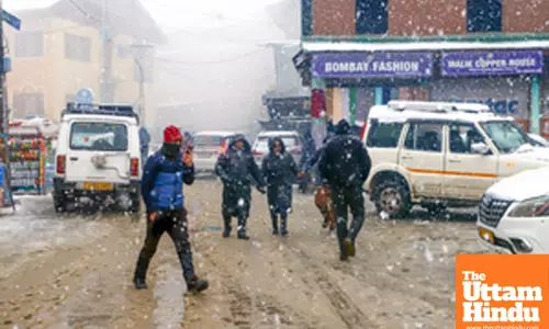 Baramulla: People walk on a snow-covered road as heavy snowfall disrupts daily life