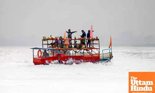 Mathura: People ride a boat through toxic foam floating on the polluted Yamuna river