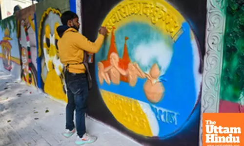 Prayagraj: An artist paints a wall with intricate and vibrant scripture