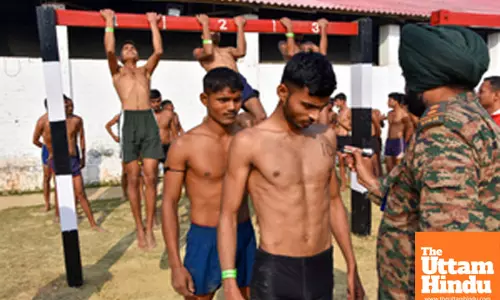 Lucknow: A security personnel writes a number on the chest of an aspirant during an ongoing recruitment drive