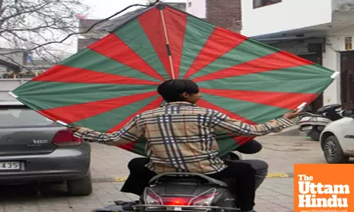 Amritsar: A man on a two-wheeler carries a large kite