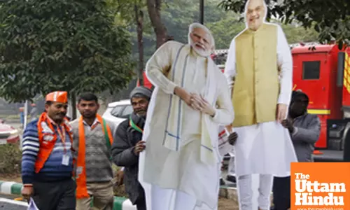 New Delhi: Supporters take cutouts of PM Modi with them after the Jhuggi Basti Pradhan Sammelan programme