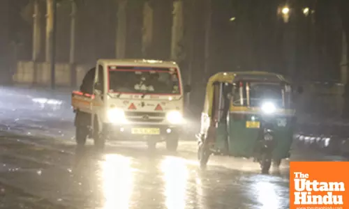 New Delhi : Vehicles pass through the streets amid rainfall