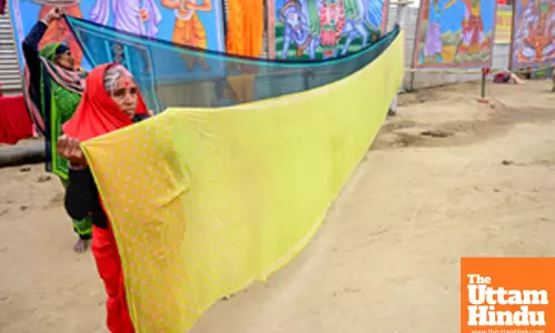 Prayagraj: Devotees dry their saree after taking a holy dip at the Triveni Sangam
