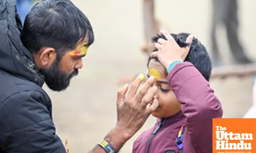 Prayagraj: A man applies Tilak to a child at the Triveni Sangam,