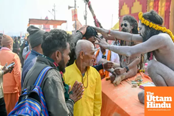 Prayagraj: A Naga Sadhu (Holy Man) applies Tilak to a man after taking a holy dip at the Triveni Sangam