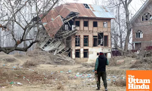 Baramulla: A security personnel stands guard outside a destroyed house at Malmooh village