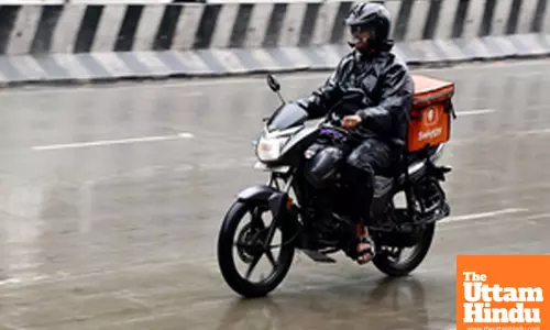 Bengaluru: A delivery partner rides his bike through a wet road after untimely rain