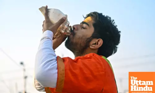 Prayagraj: A priest blows a shankh (conch shell) at Triveni Sangam