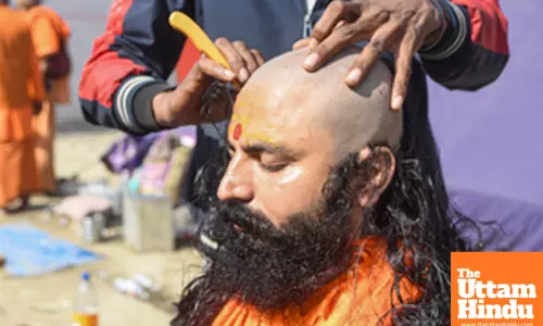 Prayagraj: A sadhu gets his head shaved at a camp during the Maha Kumbh Mela