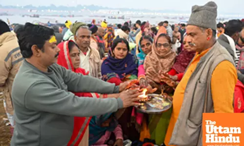 Prayagraj: A priest offers aarti to devotees at Triveni Sangam
