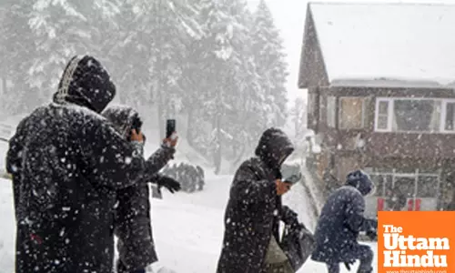 Baramulla: People walk on a snow-covered road as heavy snowfall