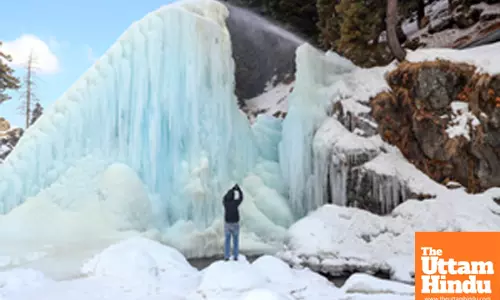 Baramulla: A tourist clicks a picture of a huge icicle