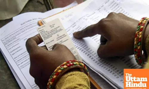 A polling official checks the identity card of a voter