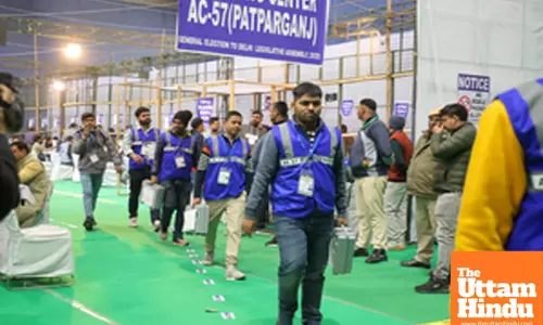 Counting officials tally votes after the Delhi Assembly election