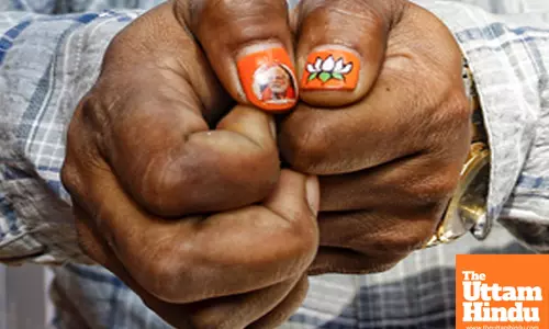 A BJP supporter flaunts nail art painted with the BJP flag