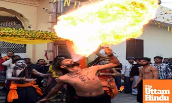 A devotee performs a fire-breathing act during a religious procession on the eve of the Maha Shivratri festival