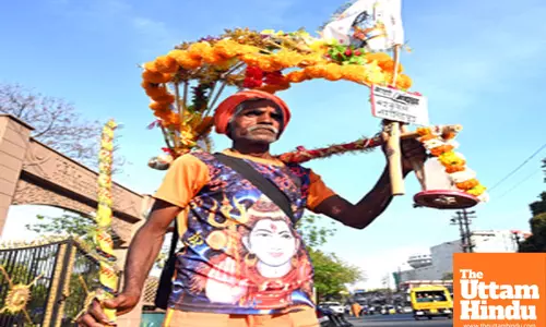 A Kanwariya carries water from the Narmada river for a ritual walk on the eve of Maha Shivratri