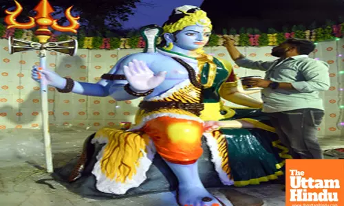 An artist gives final touches to a statue of Lord Shiva