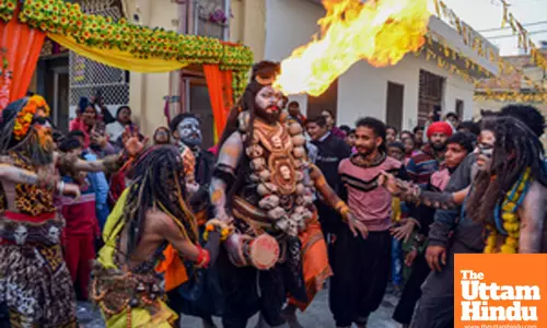 A devotee dressed as Lord Shiva participates in a religious procession on the eve of the Maha Shivratri festival