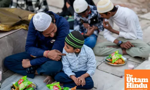 Muslim devotees share an Iftar meal during the holy month of Ramadan at Nizamuddin Dargah