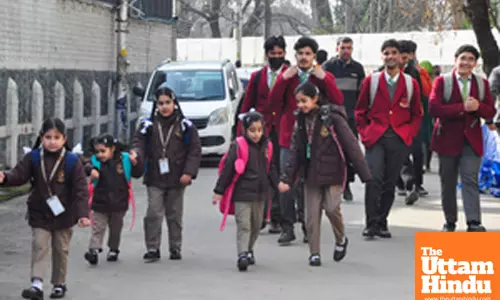 Students arrive at school to attend the first day of classes after a three-month winter vacation