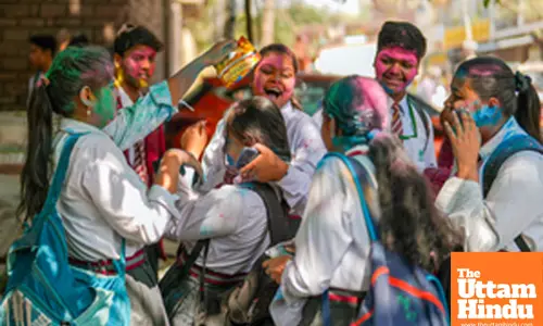 School students celebrate the upcoming Holi festival by playing with colours