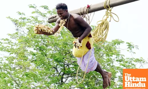 A devotee participates in the Chark Puja ritual